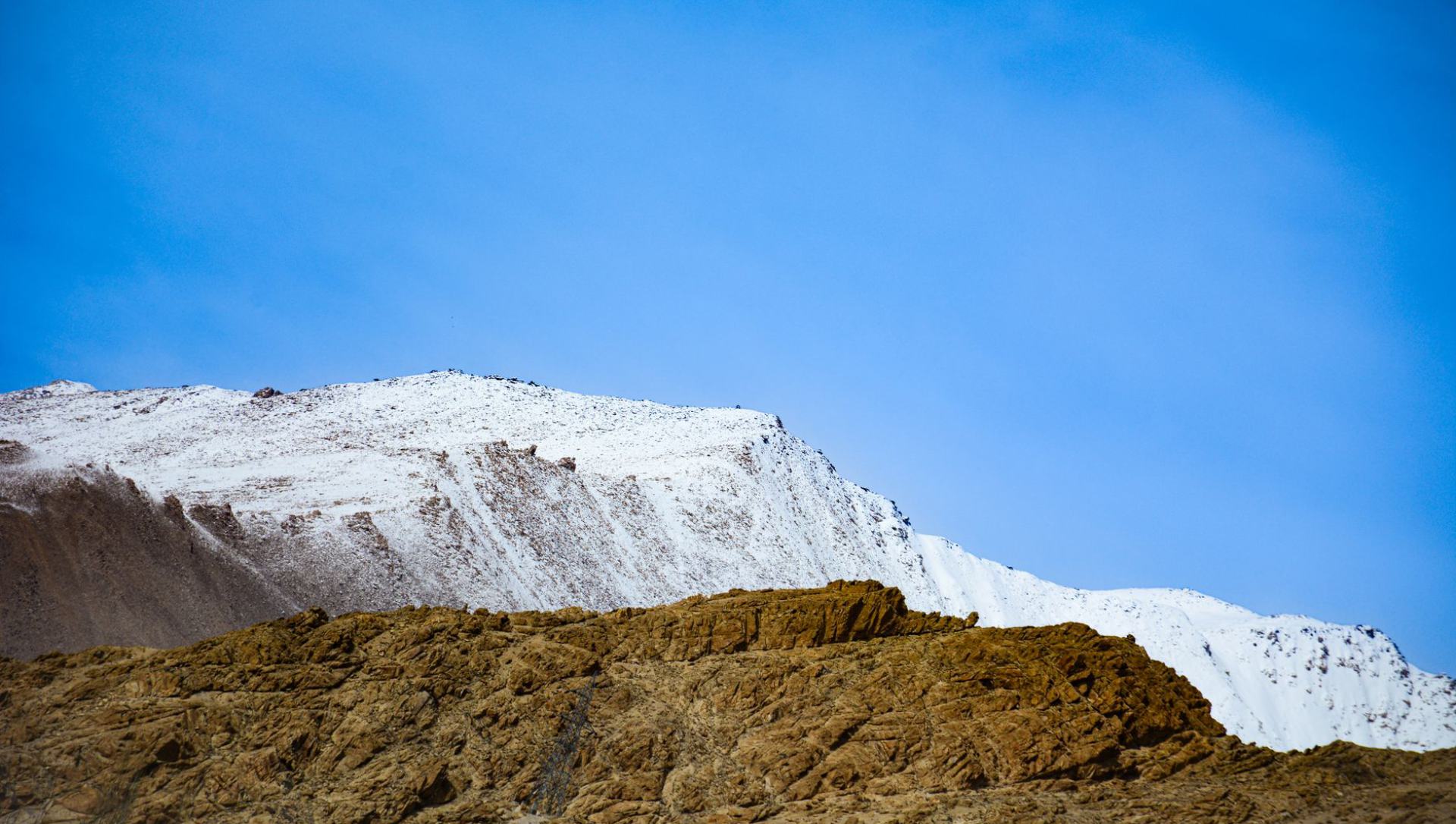 Khardung La pass road with prayer flags and mountain views