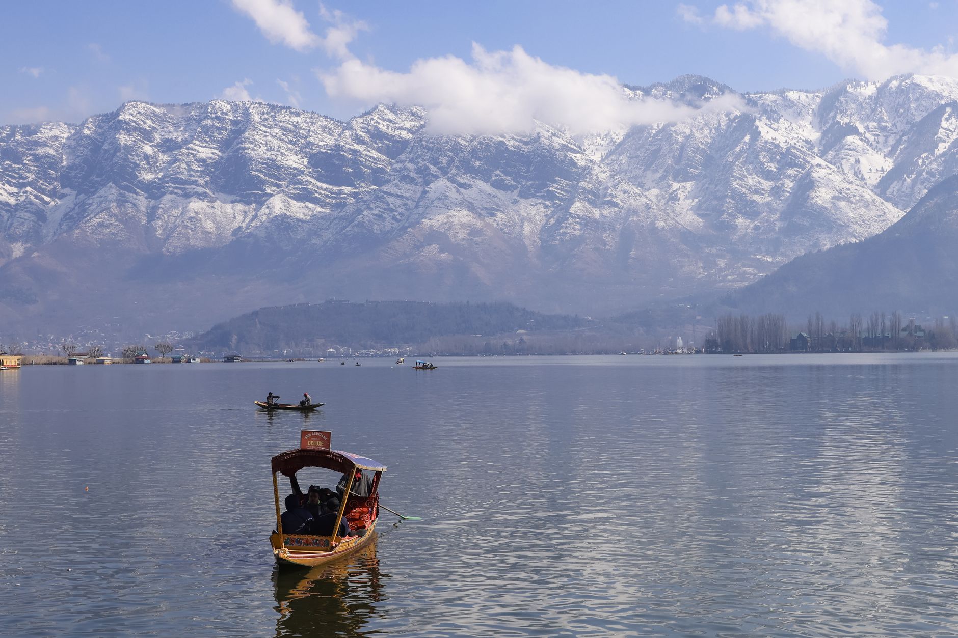 Shikara boat on Dal Lake with snow-covered mountains